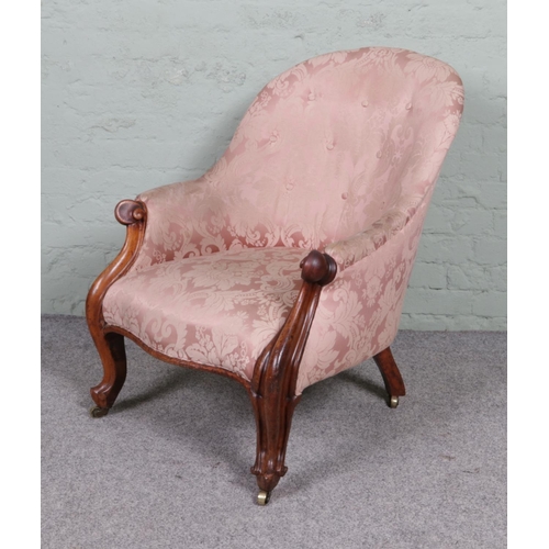 564 - A Victorian upholstered parlour chair with scrolling frame