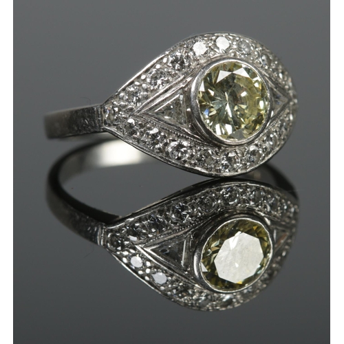 104 - A platinum and diamond ring in eliptical setting, having large central yellow diamond. Central diamo... 