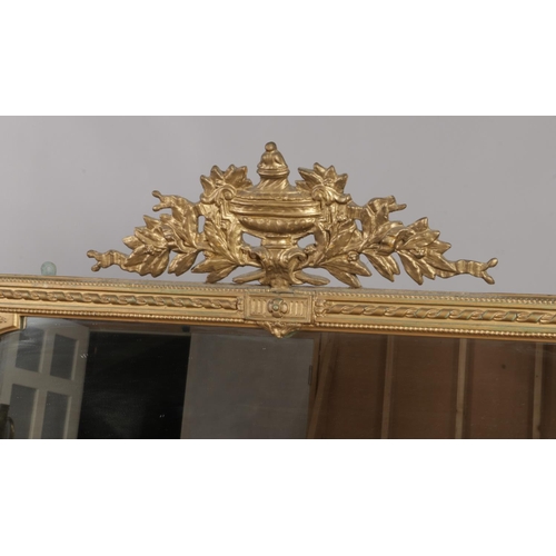 126 - An antique gilt wood over mantel mirror of neo classical design. 134cm x 115cm (without pediment).