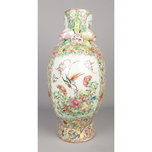 13 - A large Chinese famille rose vase. Decorated with panels depicting figures and birds and having foli... 