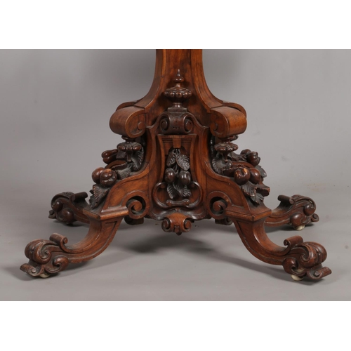 152 - A Victorian walnut fold over games table. Raised on extensively carved splayed based.