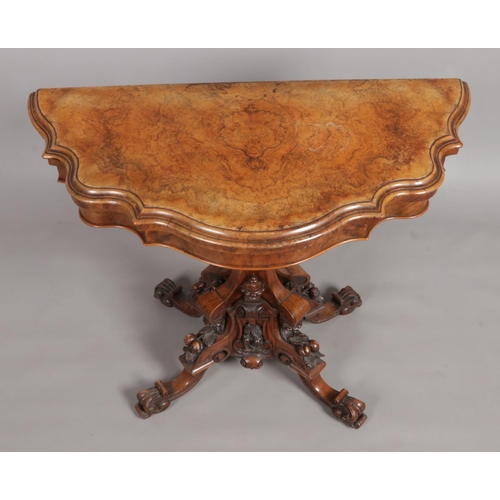 152 - A Victorian walnut fold over games table. Raised on extensively carved splayed based.