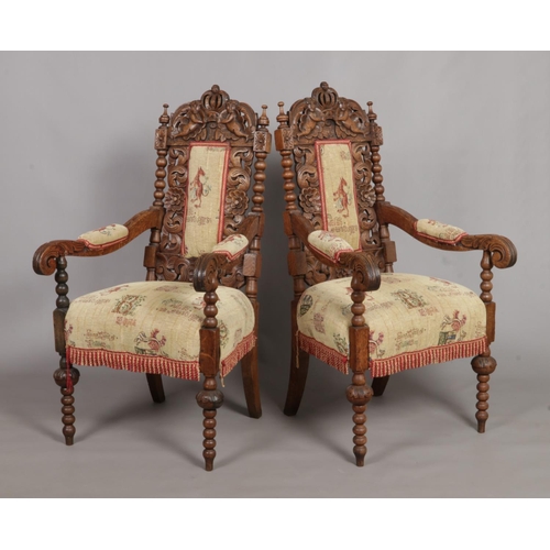 157 - A pair of carved oak throne chairs. Having cherub and crown detailing to the back rests and bobbin t... 