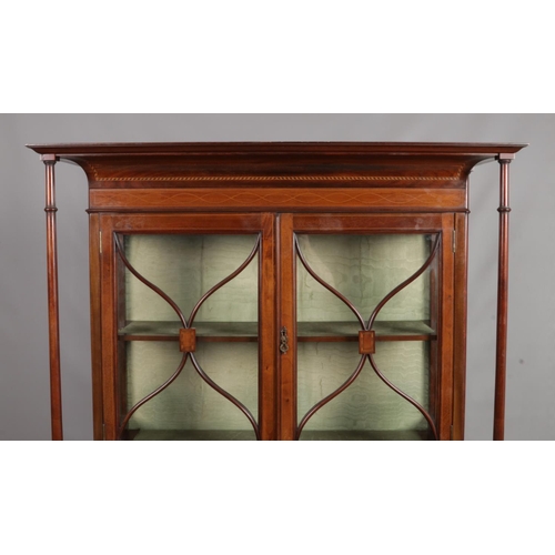 162 - An Edwardian inlaid mahogany two tier display cabinet. Having four turned column supports and taperi... 