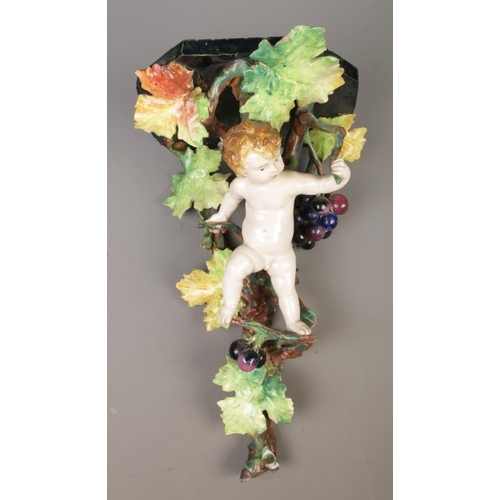 25 - A pair of Majolica style wall brackets/corbels. Decoration depicting cherubs and vines.