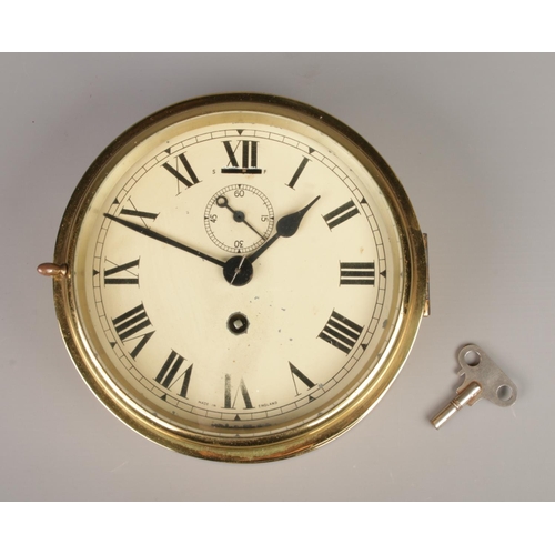 31 - A brass ships clock. Having subsidiary dial and Roman numeral markers. Made in England. Dial diamete... 