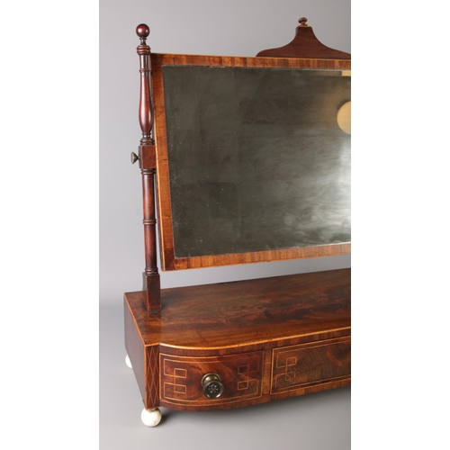 44 - A Georgian mahogany toilet mirror. Having strung inlay, three drawers and raised on bone ball feet. ... 