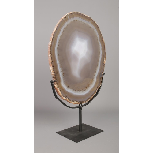 56 - A large polished agate slice on metal stand. Slice 29cm x 24cm.