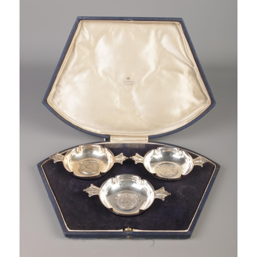 61 - Robert Edgar Stone for Asprey, a cased silver three piece commemorative quaich set. All inset with m... 