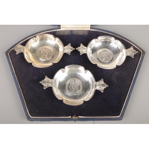 61 - Robert Edgar Stone for Asprey, a cased silver three piece commemorative quaich set. All inset with m... 