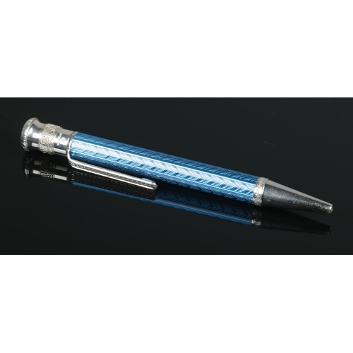 90 - A silver and blue enamel retractable ball point pen with engine turned barrel. Assayed London 2000 b... 