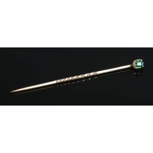 98 - An antique gold and emerald stick pin. Having part twisted stem. Length 4.7cm. 0.62g. Stone approxim... 