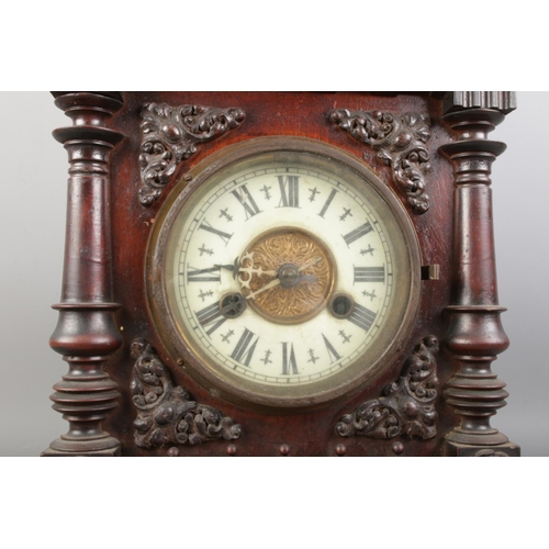 277 - A wooden decorative architectural-style mantel clock featuring a porcelain clock face with Roman num... 