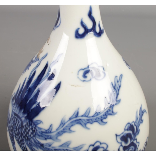 170 - A Chinese blue and white bottle vase. Decorated with a Phoenix amongst clouds. Height 22.5cm.