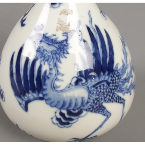 170 - A Chinese blue and white bottle vase. Decorated with a Phoenix amongst clouds. Height 22.5cm.