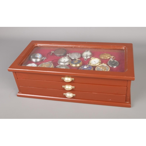 184 - A collection of quartz pocket watches housed in a three-drawer wooden watch case.