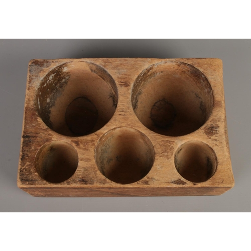 195 - An antique wooden money tray with five recesses.