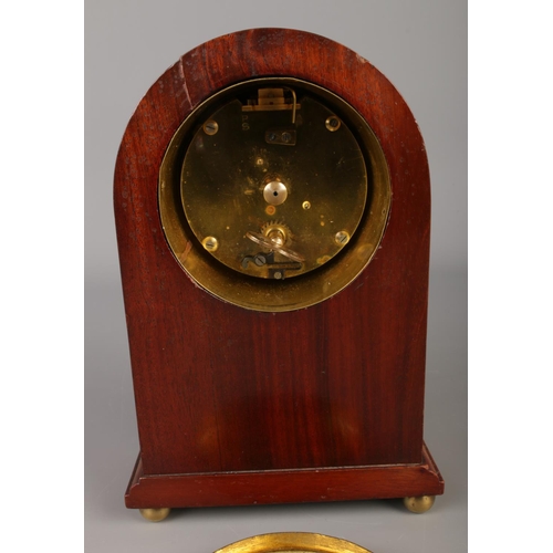 218 - A small French mahogany inlaid mantle clock with Arabic numeral dial and raised on brass ball feet. ... 