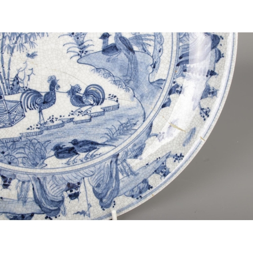 222 - A large early 20th century Chinese blue and white charger decorated with birds and flowers scenes.