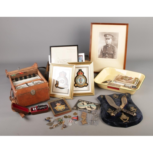 232 - A mixed quantity of collectables including framed RAF patches, shield display with mounted pair of m... 