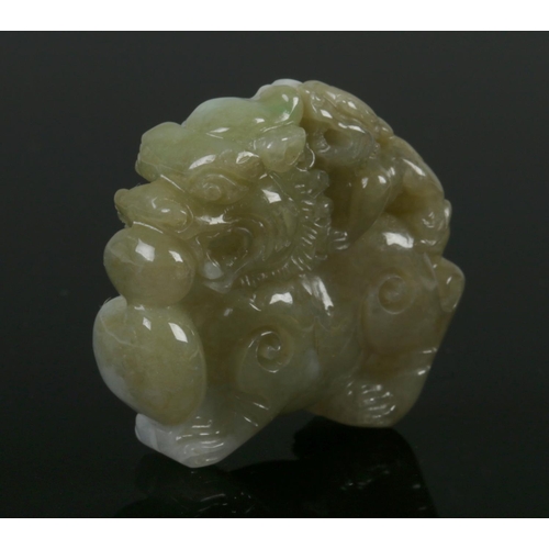 427 - An antique Chinese Jade Lion ornament, featuring a bicolour natural jade carving of temple lion with... 