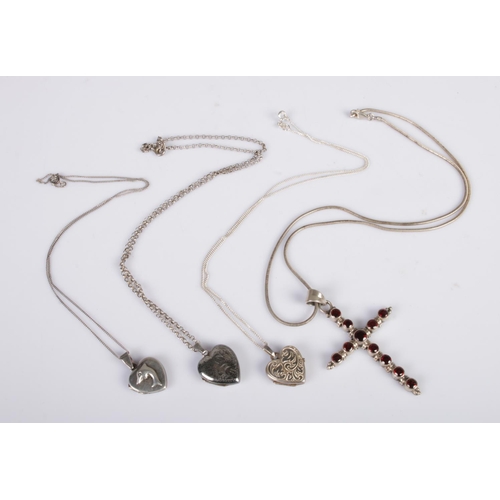 440 - A large silver crucifix set with red stones on silver chain, together with three silver heart shaped... 