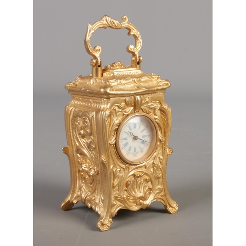 515 - A miniature French gilt carriage clock in the Art Nouveau style. Height with handle 10cm.