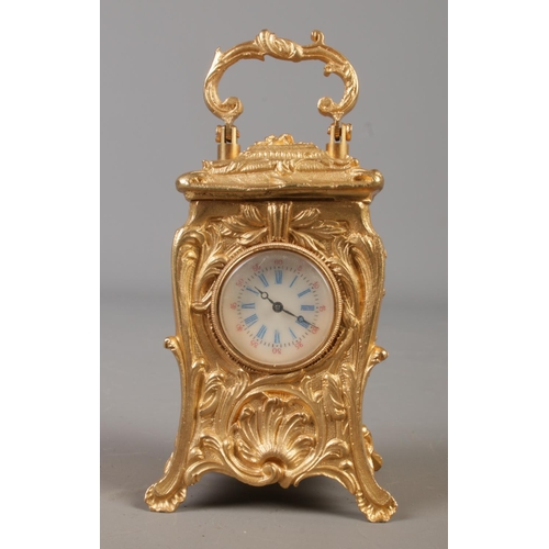 515 - A miniature French gilt carriage clock in the Art Nouveau style. Height with handle 10cm.