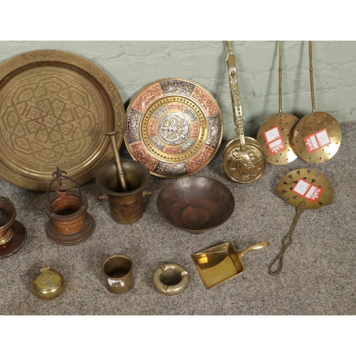 371 - A collection of assorted vintage brassware, featuring large brass charger, wall bracket, pestle & mo... 