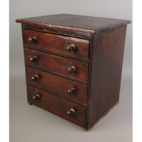 55 - An antique miniature chest of drawers with contents of costume jewellery.