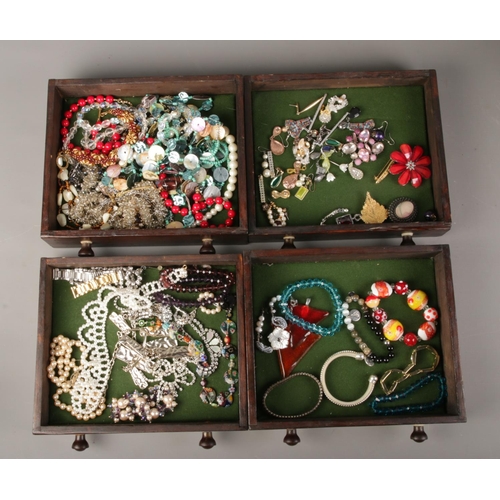 55 - An antique miniature chest of drawers with contents of costume jewellery.