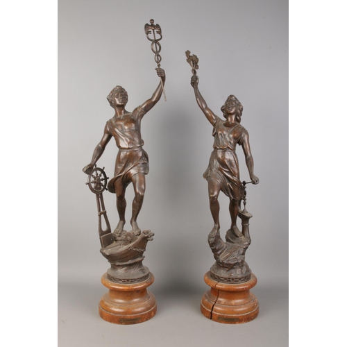 62 - A pair of French spelter figures, raised on turned bases. Titled 'Le Commerce' and 'L'Industrie'. He... 