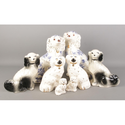 63 - A collection of Staffordshire style mantel dogs. Includes Beswick and Royal Doulton examples.