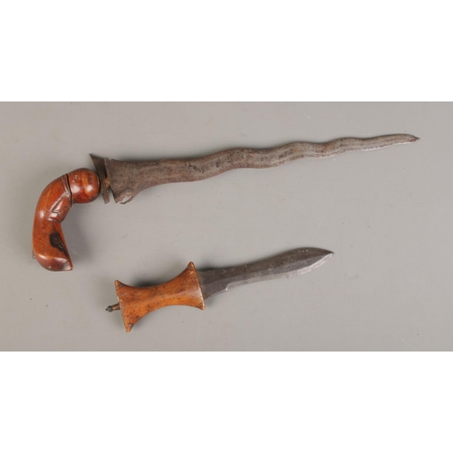 601 - A Sudanese arm knife with a tapering straight blade and a carved wooden hilt, accompanied by a South... 