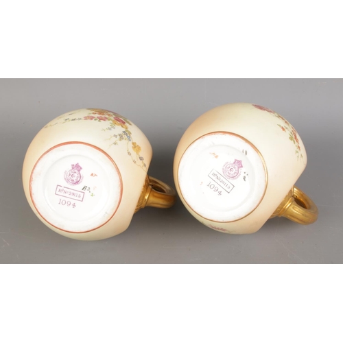 609 - A pair of Victorian Royal Worcester jugs, the bulbous bodies decorated with delicate flowers on a pe... 