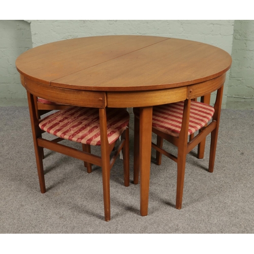 A Danish mid century Hans Olsen style teak circular extending dining table with four chairs. Height 74cm, Diameter (closed) 121cm.