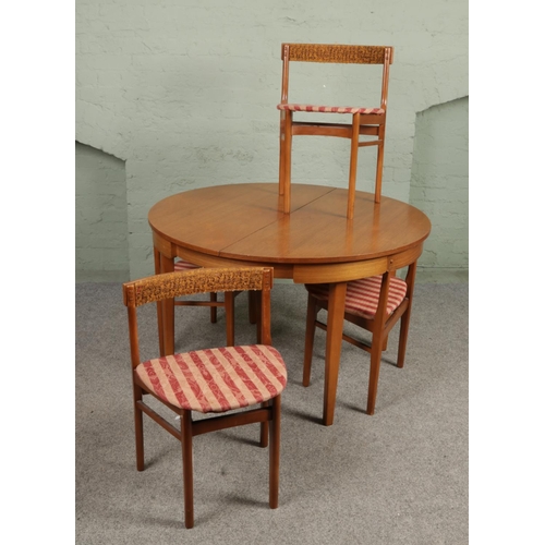 677 - A Danish mid century Hans Olsen style teak circular extending dining table with four chairs. Height ... 