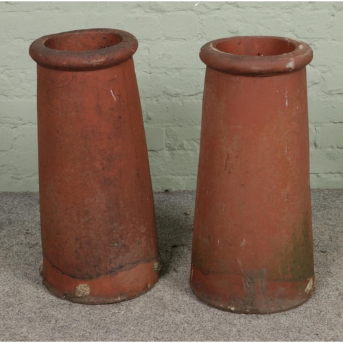 341 - A pair of cylindrical terracotta chimney pots. Approx. height 63cm.