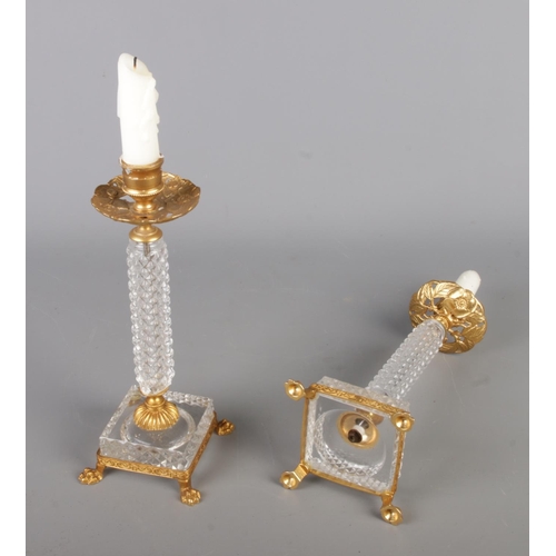 36 - Two sets of vintage candlestick holders, comprising a gilt and cut glass pair raised on lion paw fee... 