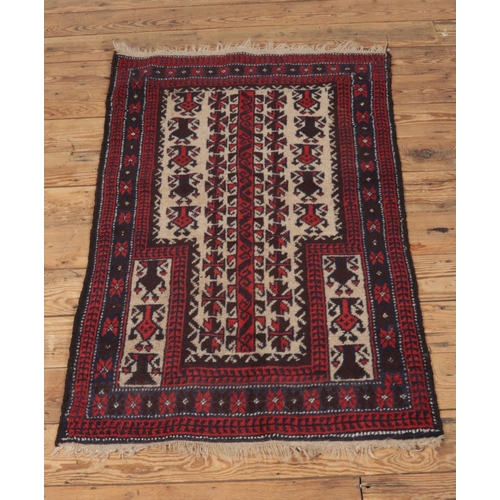 293 - A small red ground wool prayer rug featuring geometric design and fringed edges. Approx. dimensions ... 