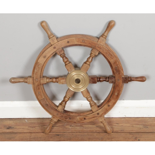 295 - A six spoke wooden ships wheel featuring brass central boss. Approx. diameter of spokes 66cm.