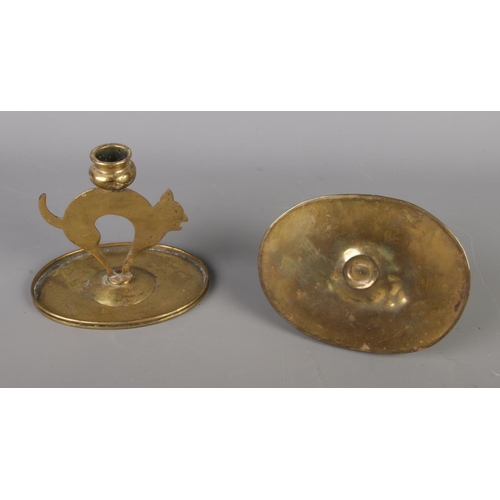 41 - A pair of brass cat-shaped candlesticks, accompanied by a wrought iron Rat De Cave candlestick featu... 