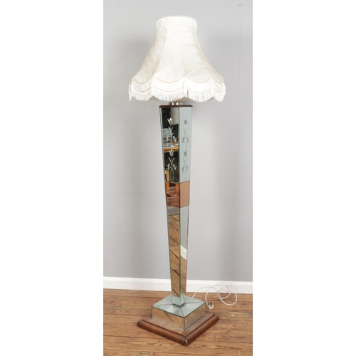 311 - A mirrored glass body floor lamp, with bevelled edges, etched floral patterns and wooden square base... 