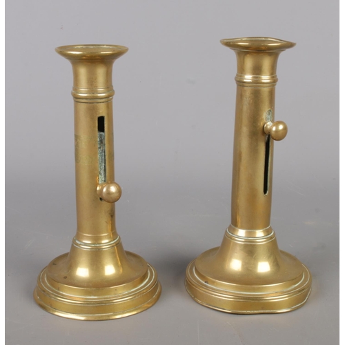 48 - A pair of 19th century brass candlesticks, featuring integral sliding height adjuster on round turne... 