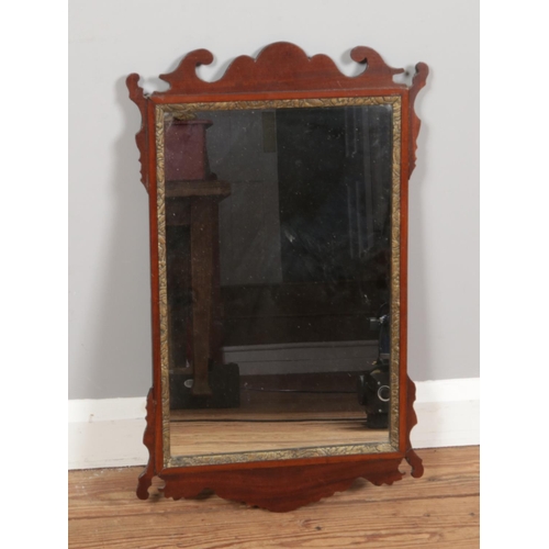 374 - A Georgian style wall mirror with a rectangular glass framed in a mahogany surround. It features a s... 