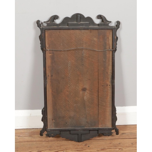 374 - A Georgian style wall mirror with a rectangular glass framed in a mahogany surround. It features a s... 