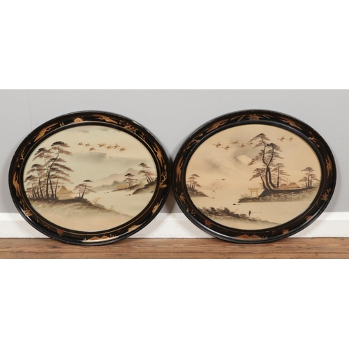 376 - A pair of early 20th century watercolours, river scenes, in Japanned oval frames. 39cm x 48cm.