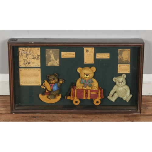 385 - A framed display showcasing the history of the teddy bear and includes a trio of ceramic teddy bear ... 