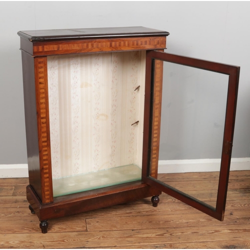 527 - A Victorian walnut pier cabinet, featuring marquetry patterns, two glass shelves and resting on four... 