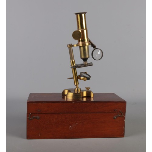 29 - An antique brass scholar's microscope, with accessories and original walnut wooden case.